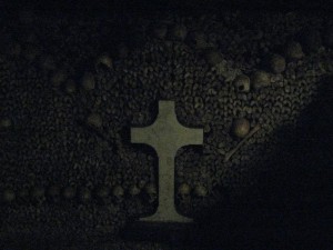 Memorial cross in front of the ossuary bone piles.